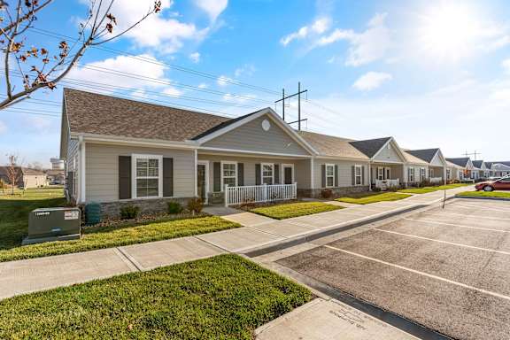 A sunny day at a residential area with houses and a parking lot.
