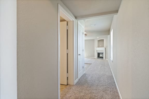 an empty hallway with a door open to a living room