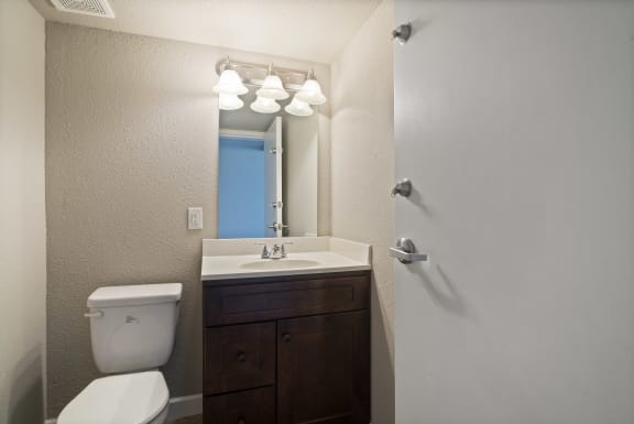 a bathroom with a toilet sink and mirror and a shower