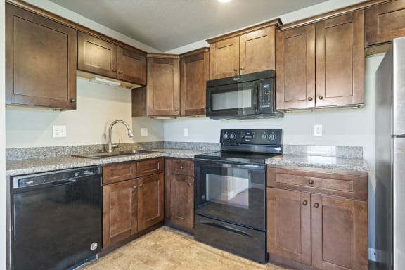 a kitchen with black appliances and wooden cabinets
