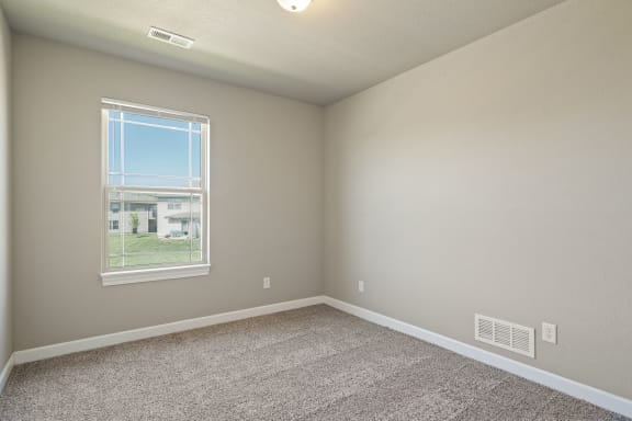 an empty room with carpet and a window