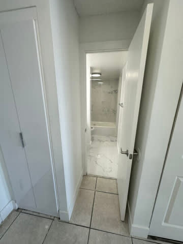 A white door is open to a bathroom.