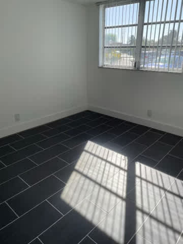 A room with a window and sunlight shining through.