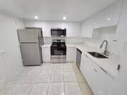 A kitchen with white cabinets and a stainless steel refrigerator.