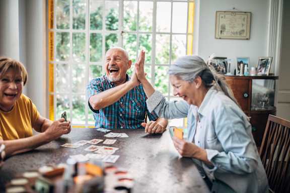 a man and a woman are sitting at a table with cards in front of them and are