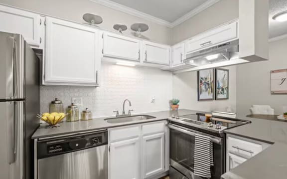 A modern kitchen with stainless steel appliances and white cabinets.