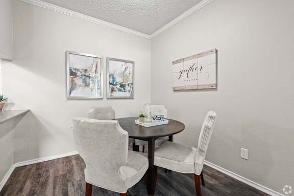 A dining room with a table and chairs.