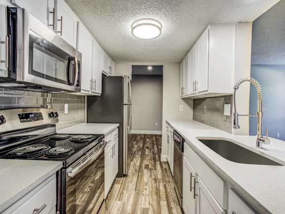 A kitchen with white cabinets and a black stove top oven.