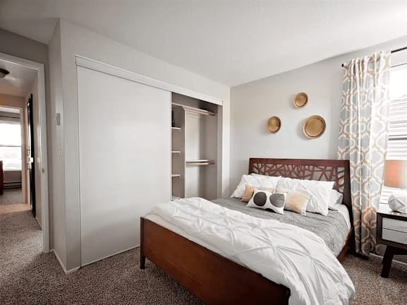 A bedroom with a bed, nightstand, and a wall with three circular decorations.