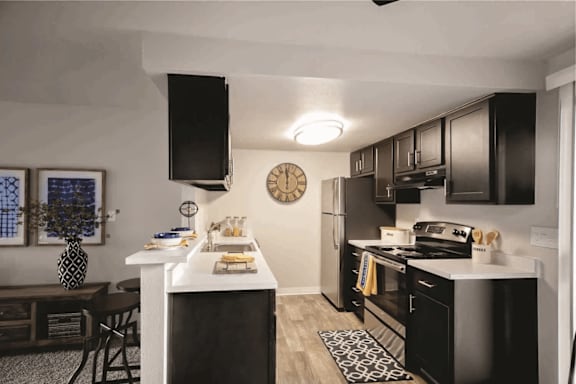 A black and white kitchen with a clock on the wall.