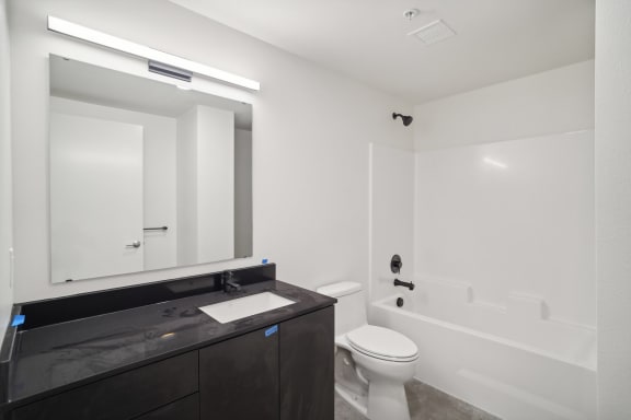 a bathroom with a toilet sink and a mirror at Analog PDX Apartments, Oregon