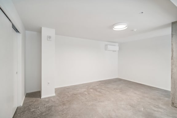an empty room with white walls and a concrete floor at Analog PDX Apartments, Portland, OR 97227
