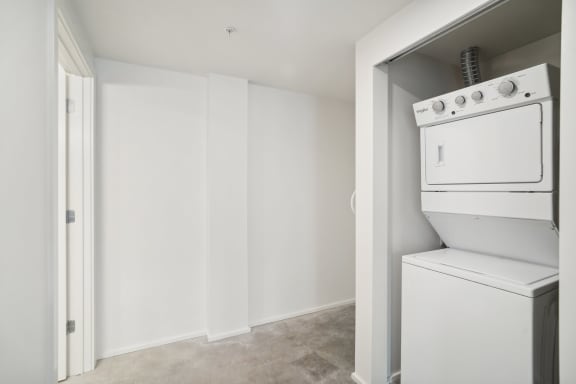 an empty laundry room with a washer and dryer in it at Analog PDX Apartments, Portland, OR