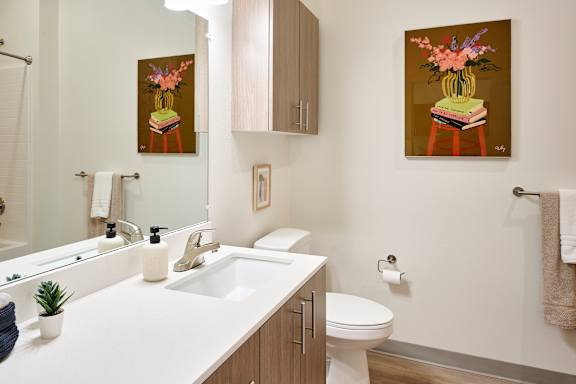 A bathroom with a white counter top and a toilet.