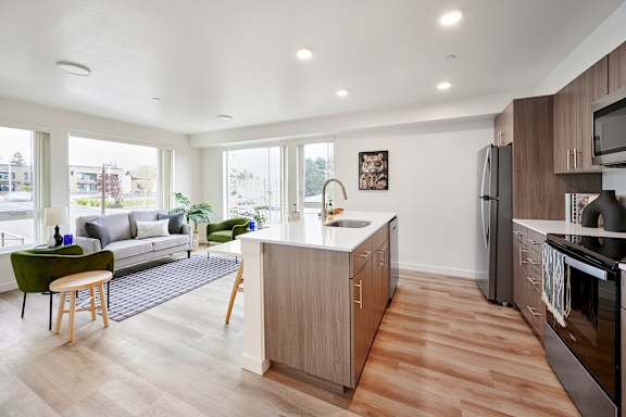 A modern kitchen with wooden floors and appliances.