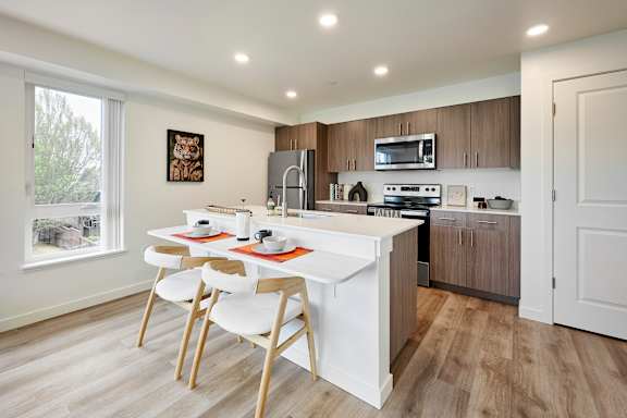 A kitchen with a white table and chairs.