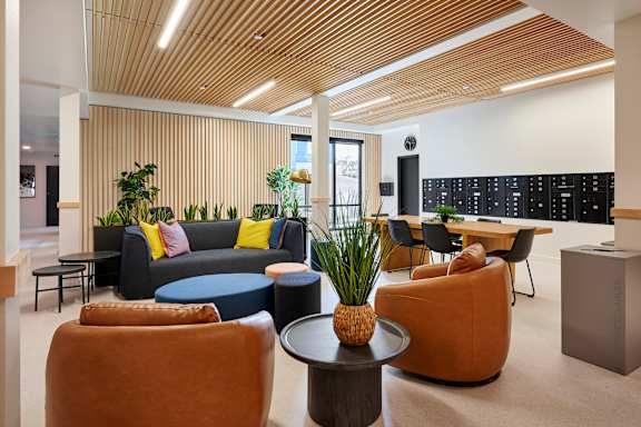 A modern living room with a wooden ceiling and a variety of seating options.