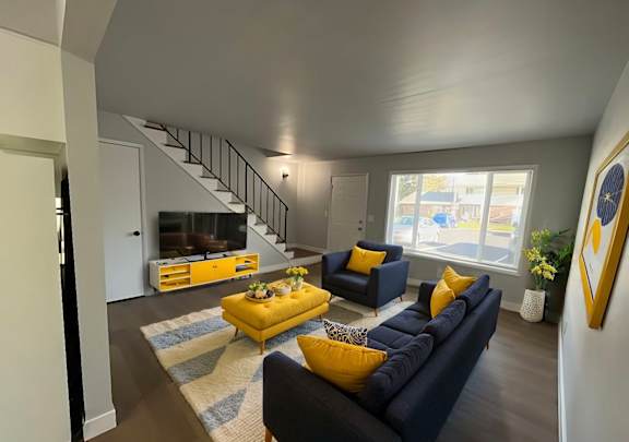A living room with a yellow sofa and a blue couch.