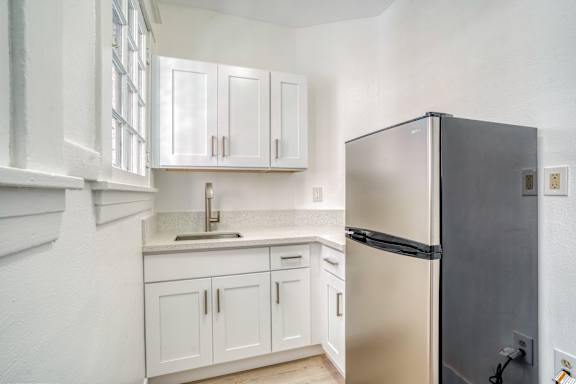 A kitchen with white cabinets and a black refrigerator at Clay & Tiffany, Portland, 97201