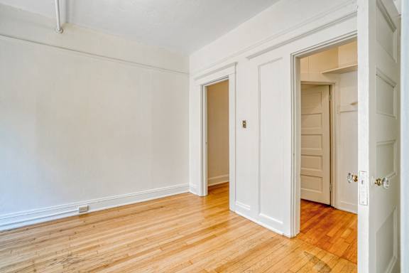 A room with white walls and wooden floors with two doors at Clay & Tiffany, Portland, 97201