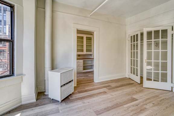 A white cabinet with drawers is in a room with a window and a door at Clay & Tiffany, Portland, 97201