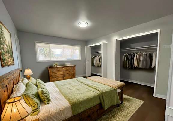 A bedroom with a bed, a dresser, and a wardrobe.