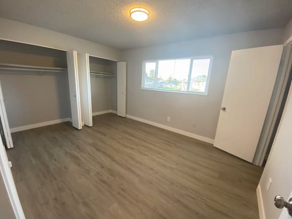 an empty living room with a closet and a window