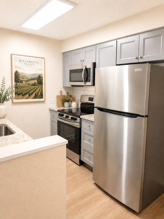 Kitchen with stainless appliances and gray cabinetry at Laurel on 2nd Apartments, Newberg, OR