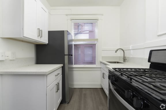 a kitchen with white cabinets and a stove and a window at Clay &amp; Tiffany, Portland, OR, 97201