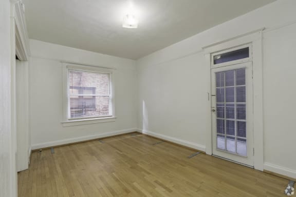 a bedroom with a door and a window and a wooden floor at Clay &amp; Tiffany, Portland, OR
