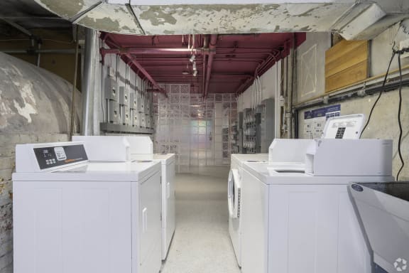 a laundromat with four washing machines in a long room with exposed wiring at Clay & Tiffany, Portland, OR, 97201
