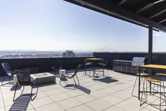 a rooftop patio with tables and chairs and a view of the city at Moraine, Tacoma, Washington 98402