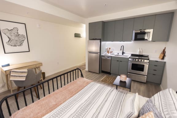a bedroom with a bed and a kitchen with stainless steel appliances at Moraine, Washington 98402