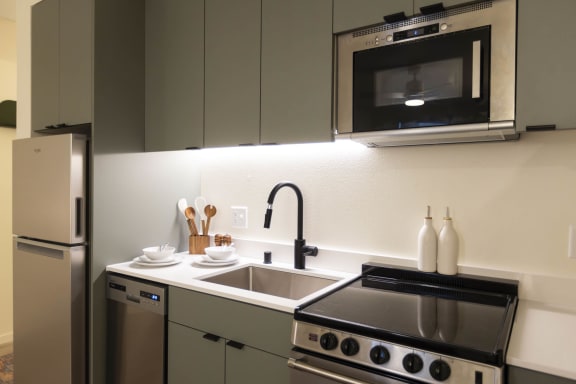 a kitchen with a sink and a stove and a microwave at Moraine, Tacoma, Washington 98402
