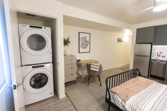 a washer and dryer in a living room with a desk and a kitchen at Moraine, Tacoma, WA