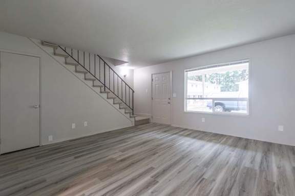 an empty room with a staircase and a large window