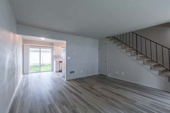 an empty room with a staircase in the background