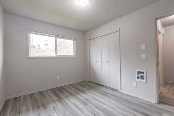 an empty room with a large window and white walls