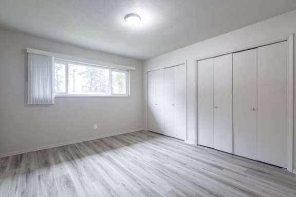 an empty bedroom with white walls and white closets