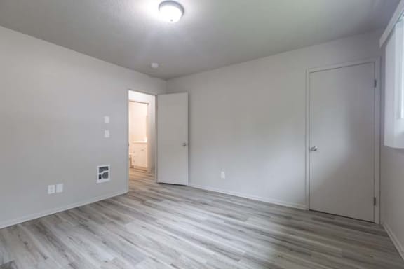 an empty room with white walls and a wooden floor