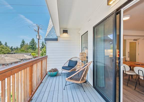 A wooden deck with a chair and a table at Society 62 Apartments, Portland, Oregon