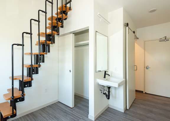 A white bathroom with a black metal staircase at Society 62 Apartments, Oregon