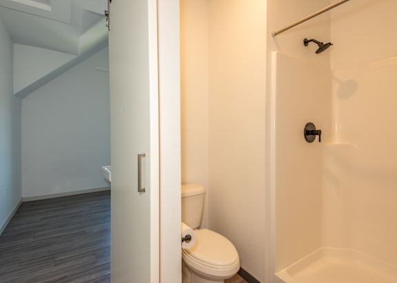 A white toilet in a small bathroom with a white tub at Society 62 Apartments, Oregon, 97213