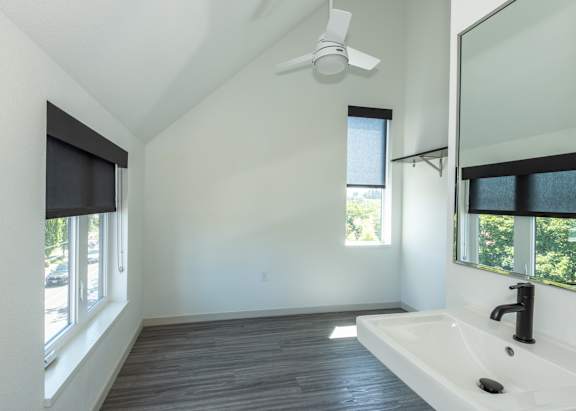 A bathroom with a white sink and a ceiling fan at Society 62 Apartments, Oregon, 97213 at Society 62 Apartments, Portland, OR, 97213