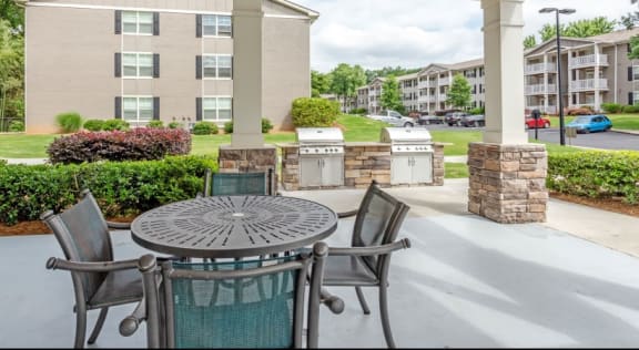 a patio with a table and chairs in front of an apartment complex  at The Bristol Apartments, Greenville, 29601