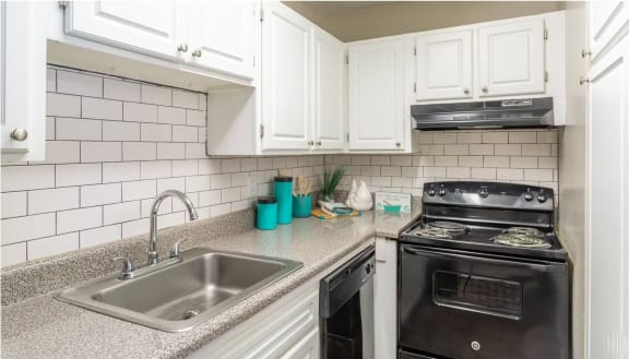 a kitchen with white cabinets and black appliances at Bradley Square Apartments, South Carolina, 29406