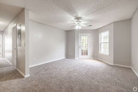 A spacious room with a ceiling fan and carpeted floor at Cross Creek Apartments, Beaufort, SC, 29906