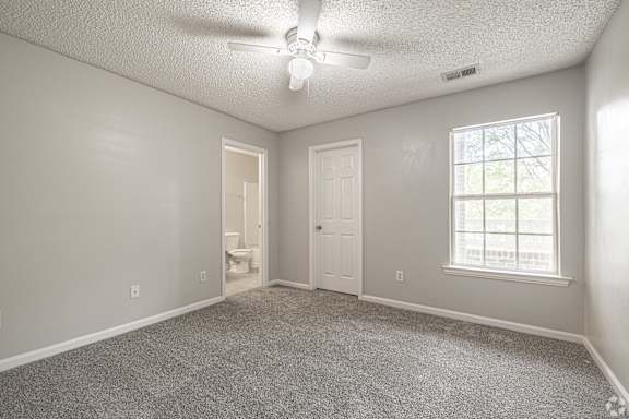 A room with a carpeted floor, a ceiling fan, and a window with blinds at Cross Creek Apartments, Beaufort, SC, 29906