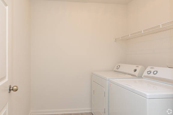 A white laundry room with a washer and dryer at The Regency Apartment Homes, Manassas, VA
