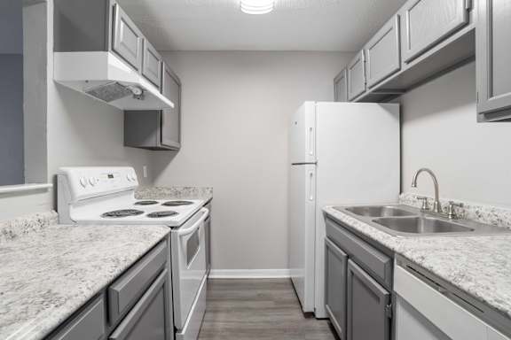 A kitchen with a white stove and a white refrigerator.at Jamestown Pointe Apartments, Greenville, SC 29607